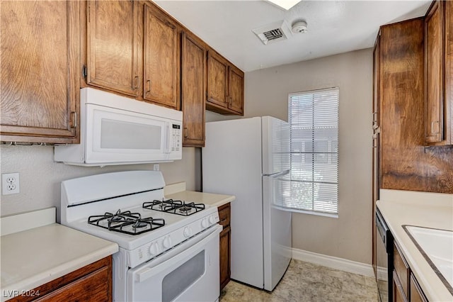 kitchen with sink, a wealth of natural light, and white appliances