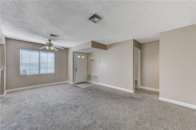 unfurnished room featuring light carpet, a textured ceiling, and ceiling fan