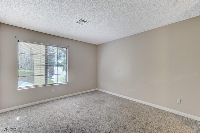 carpeted spare room featuring a textured ceiling