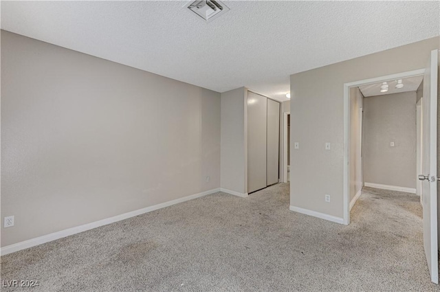 carpeted spare room with a textured ceiling