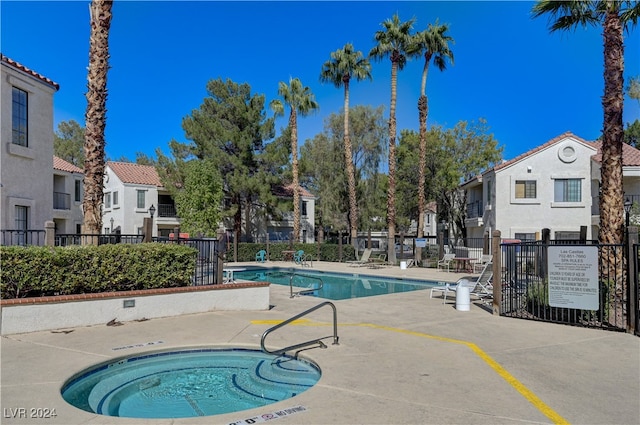 view of swimming pool featuring a hot tub and a patio