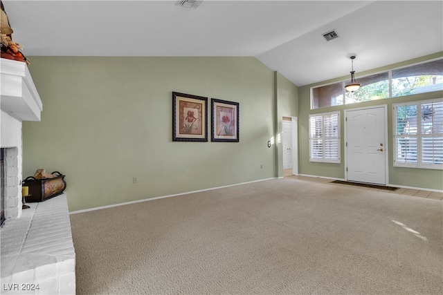 unfurnished living room featuring a healthy amount of sunlight, light colored carpet, and vaulted ceiling