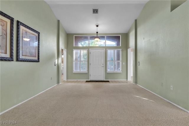 entrance foyer featuring light carpet and vaulted ceiling