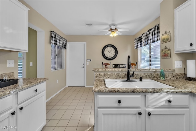 kitchen with light stone countertops, ceiling fan, sink, light tile patterned floors, and white cabinets