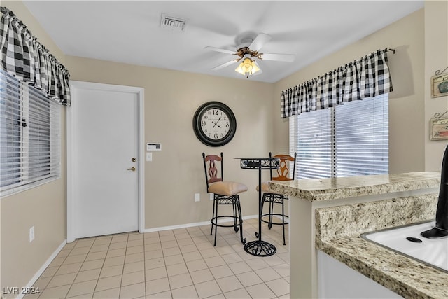 tiled dining space with ceiling fan