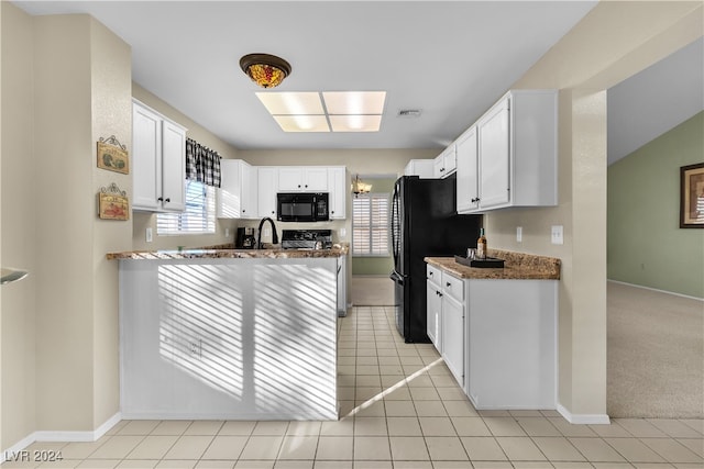 kitchen featuring black appliances, light tile patterned flooring, white cabinets, and light stone counters