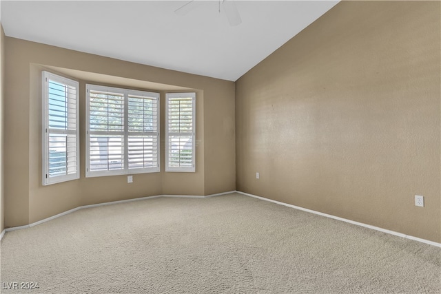 carpeted spare room featuring ceiling fan and lofted ceiling