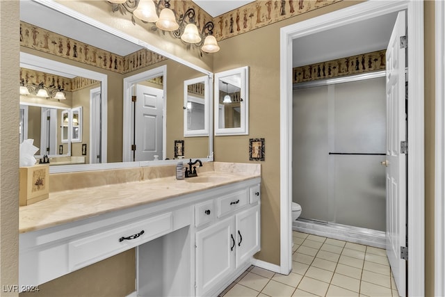 bathroom featuring toilet, vanity, tile patterned floors, and a shower with shower door