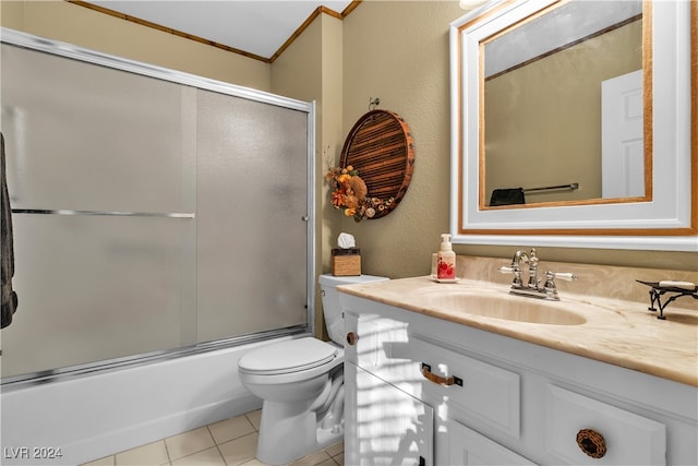 full bathroom featuring vanity, tile patterned floors, toilet, enclosed tub / shower combo, and ornamental molding