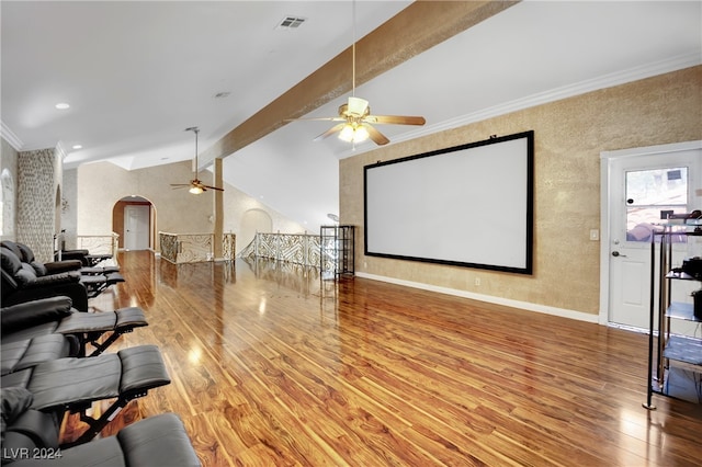 cinema room with vaulted ceiling with beams, ornamental molding, hardwood / wood-style flooring, and ceiling fan