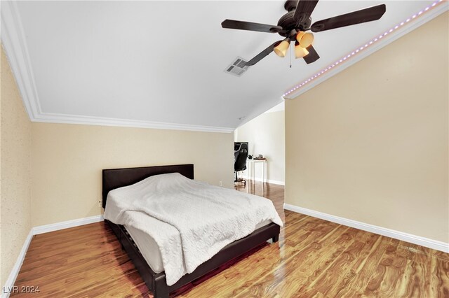 bedroom featuring ceiling fan, wood-type flooring, and ornamental molding