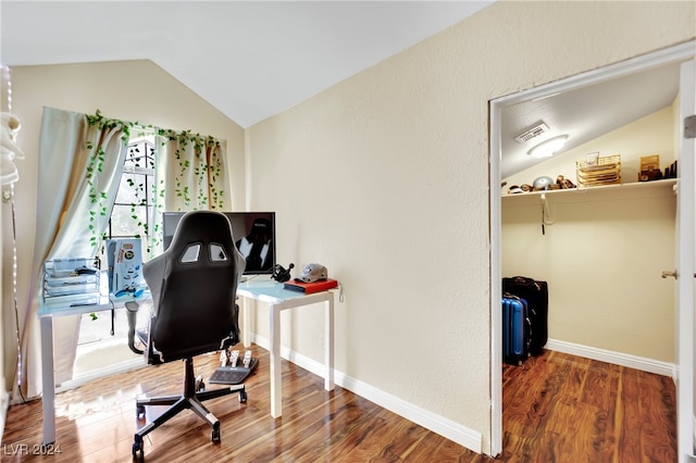 home office with lofted ceiling, hardwood / wood-style flooring, and a wealth of natural light