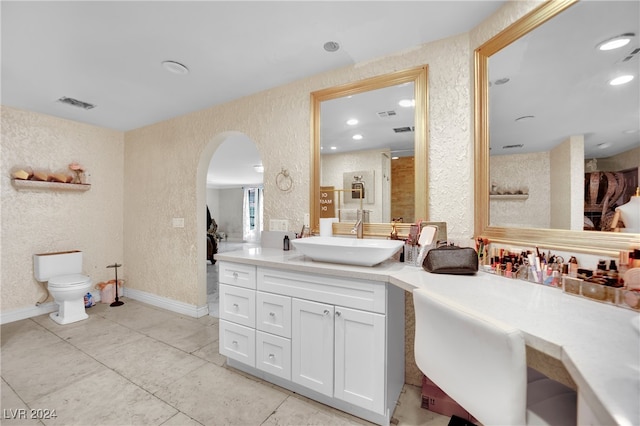 bathroom with toilet, walk in shower, vanity, and tile patterned floors