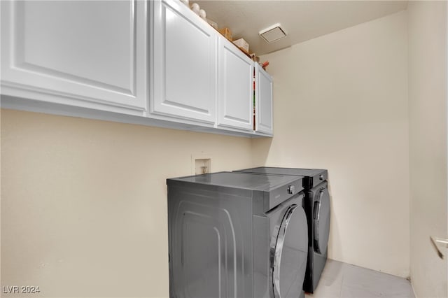 laundry room with cabinets and washer and dryer