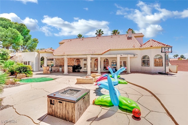 rear view of house featuring a patio area and a fire pit