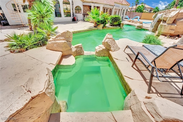 view of pool featuring a patio and an in ground hot tub