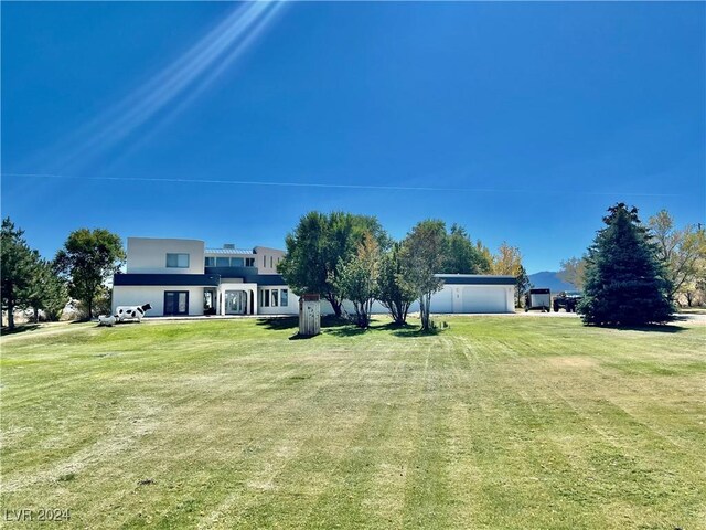 291E Madison Ave, Ely, NV 89301 - view of green lawn with driveway and a garage