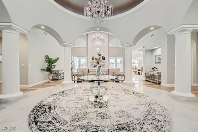 entrance foyer with a towering ceiling, light hardwood / wood-style floors, and an inviting chandelier