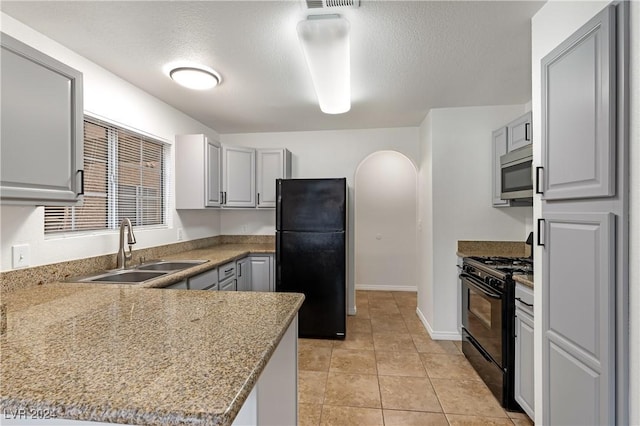 kitchen with kitchen peninsula, gray cabinetry, a textured ceiling, sink, and black appliances