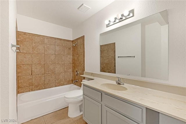 full bathroom featuring tile patterned flooring, tiled shower / bath combo, toilet, and vanity