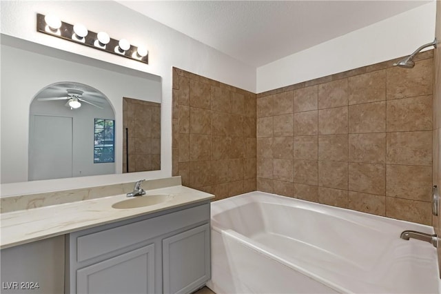 bathroom with vanity, a textured ceiling, tiled shower / bath combo, and ceiling fan