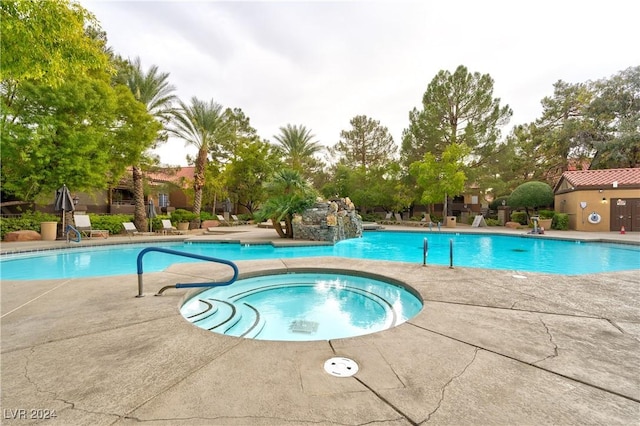 view of pool with a patio and a hot tub