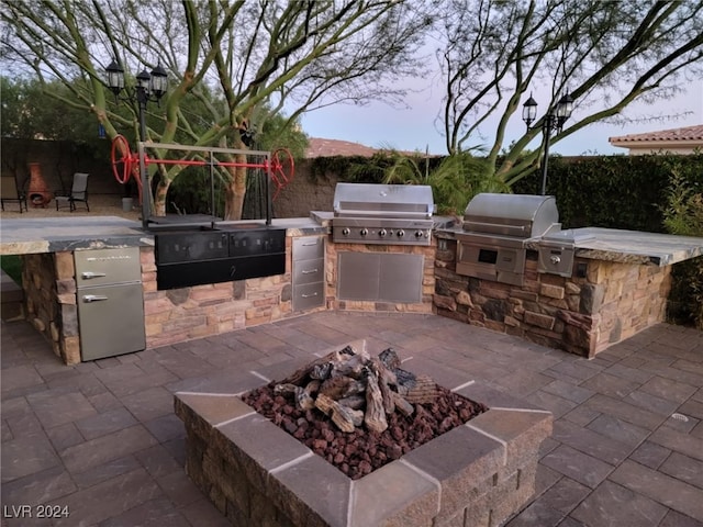 view of patio / terrace featuring an outdoor fire pit, area for grilling, and grilling area