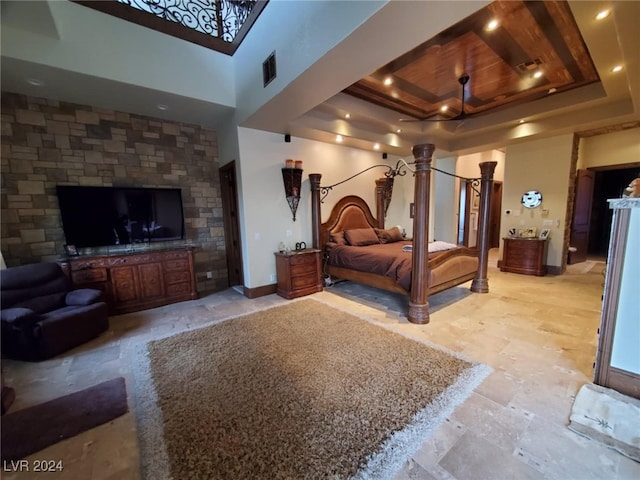 bedroom with visible vents, a raised ceiling, baseboards, and decorative columns