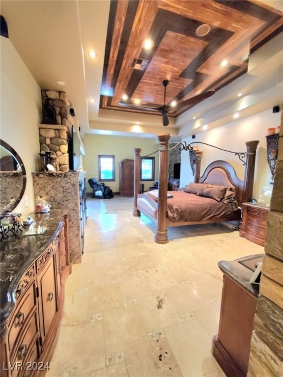 bedroom featuring a tray ceiling, visible vents, and decorative columns