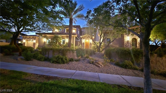 view of front of home with stucco siding, stone siding, and a tiled roof