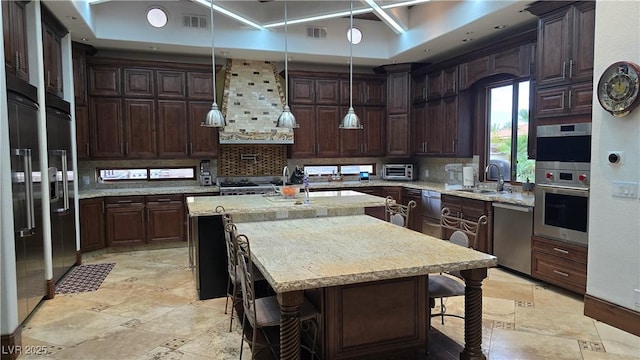 kitchen featuring a sink, an island with sink, visible vents, and stainless steel appliances