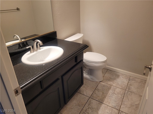 bathroom featuring tile patterned floors, vanity, and toilet