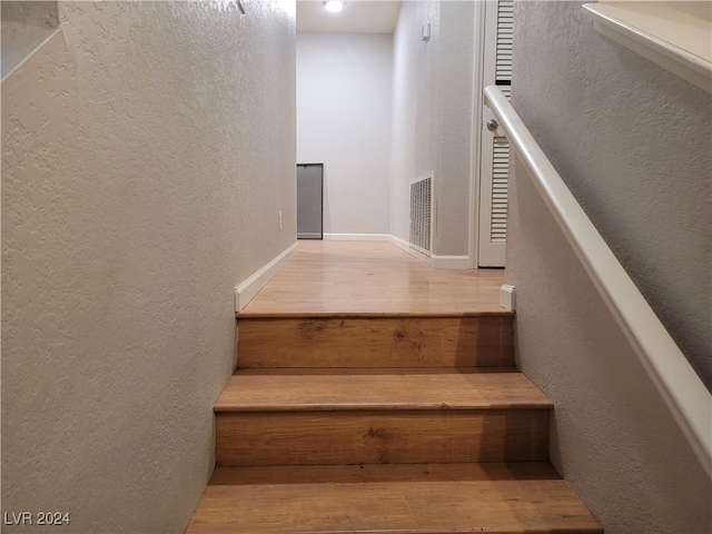 stairs featuring hardwood / wood-style floors