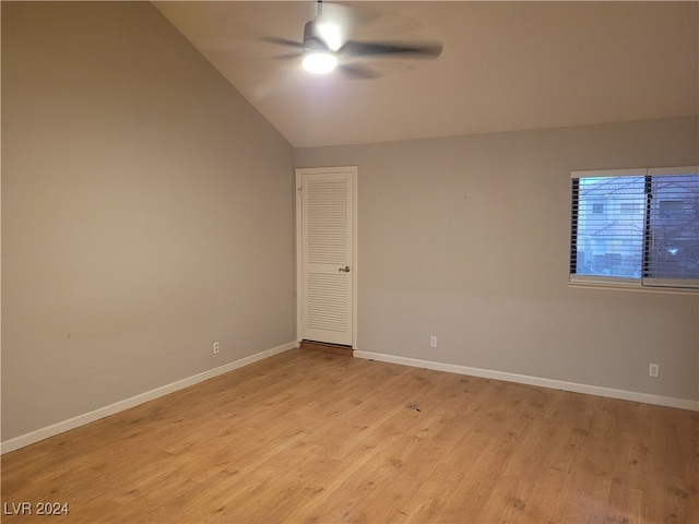 spare room featuring lofted ceiling, ceiling fan, and light wood-type flooring