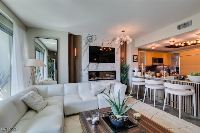 living room featuring a high end fireplace and an inviting chandelier