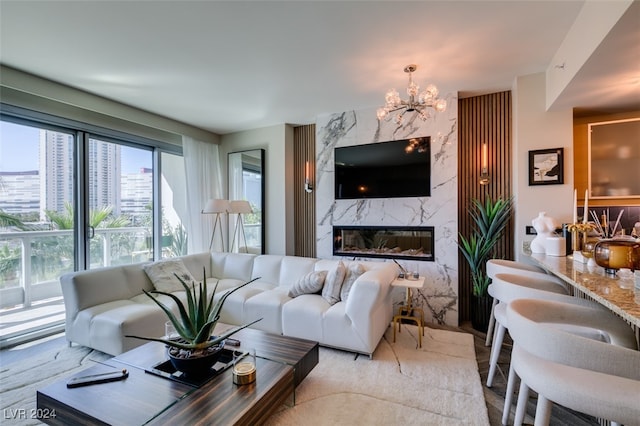 living room with a premium fireplace and an inviting chandelier