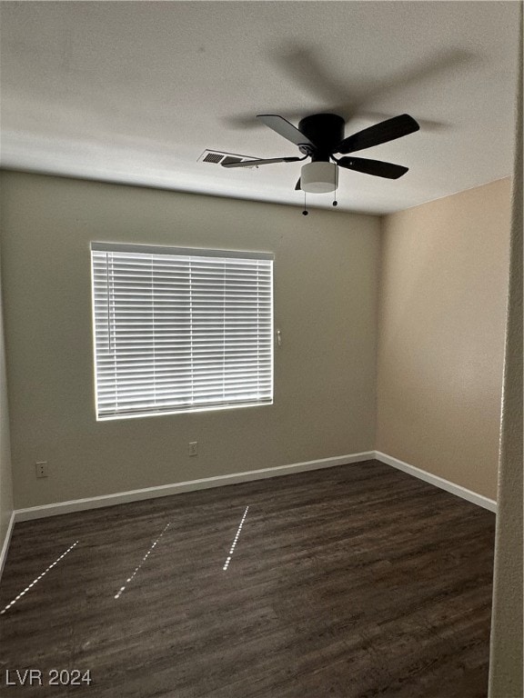 empty room with a textured ceiling, dark hardwood / wood-style floors, and ceiling fan