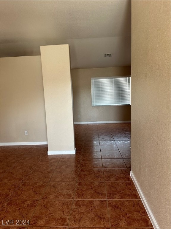 spare room featuring dark tile patterned floors