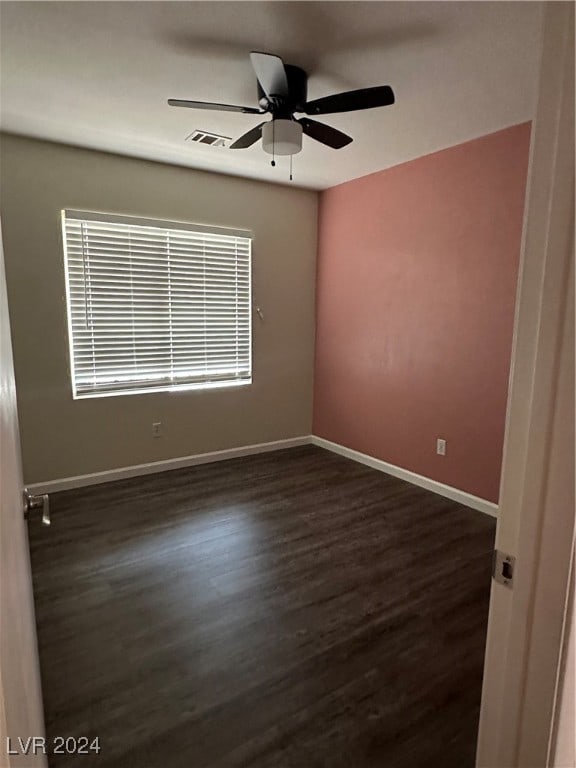 unfurnished room featuring dark wood-type flooring and ceiling fan