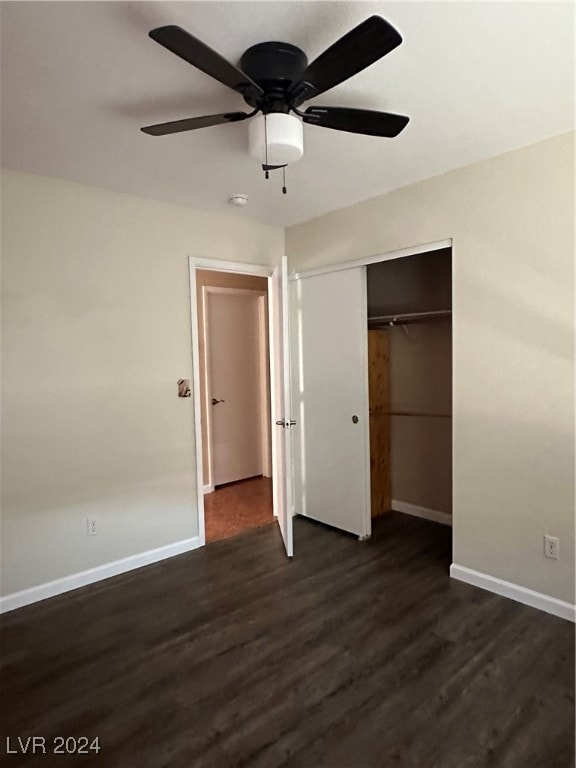 unfurnished bedroom with dark hardwood / wood-style flooring, a closet, and ceiling fan