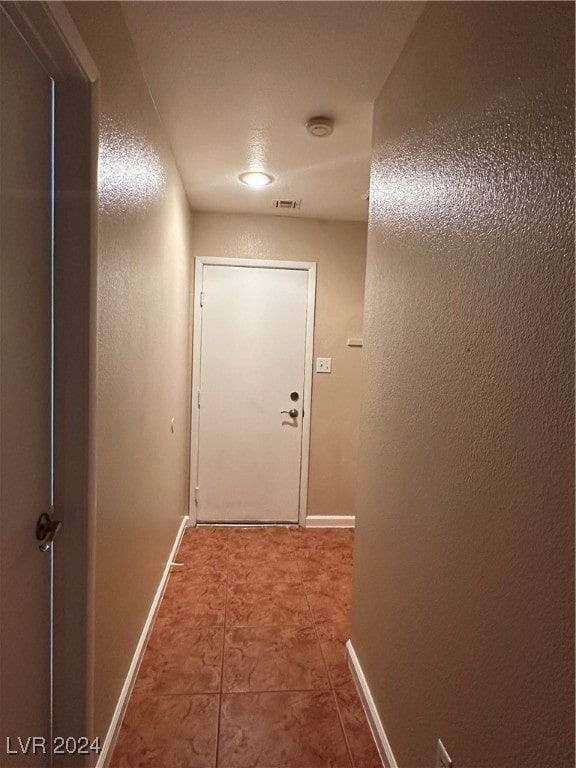 hallway with tile patterned floors