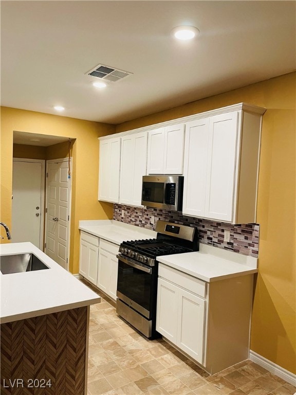 kitchen featuring white cabinets, stainless steel appliances, and sink