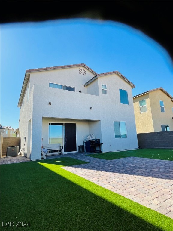 rear view of house featuring a yard and a patio area