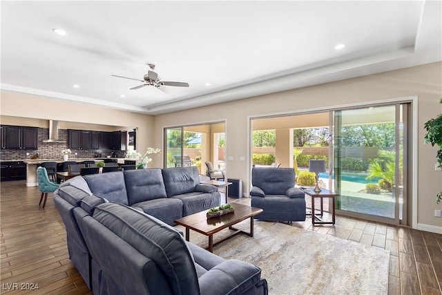 living room with ceiling fan and a tray ceiling