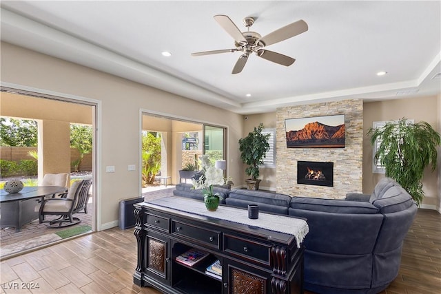 living room featuring ceiling fan and a fireplace