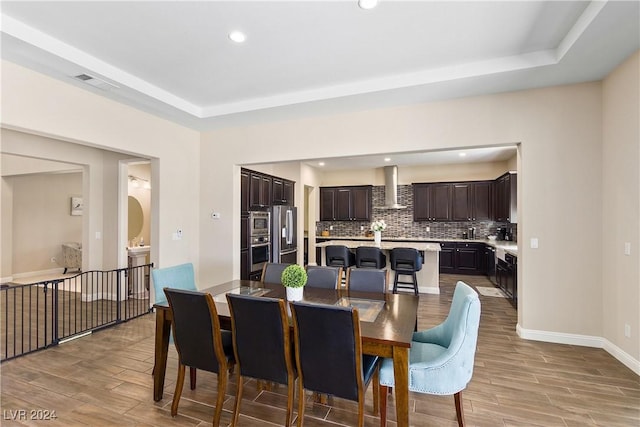 dining space with a raised ceiling