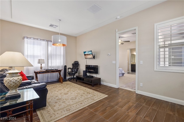 living room featuring ceiling fan with notable chandelier