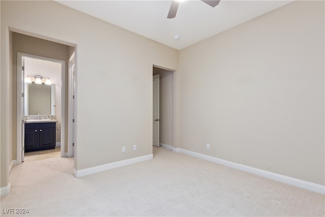 unfurnished bedroom featuring sink, light carpet, connected bathroom, and ceiling fan