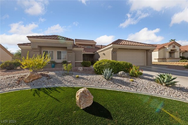 mediterranean / spanish-style house with a front lawn and a garage