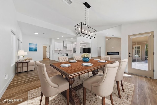 dining room with sink, light hardwood / wood-style floors, and ceiling fan